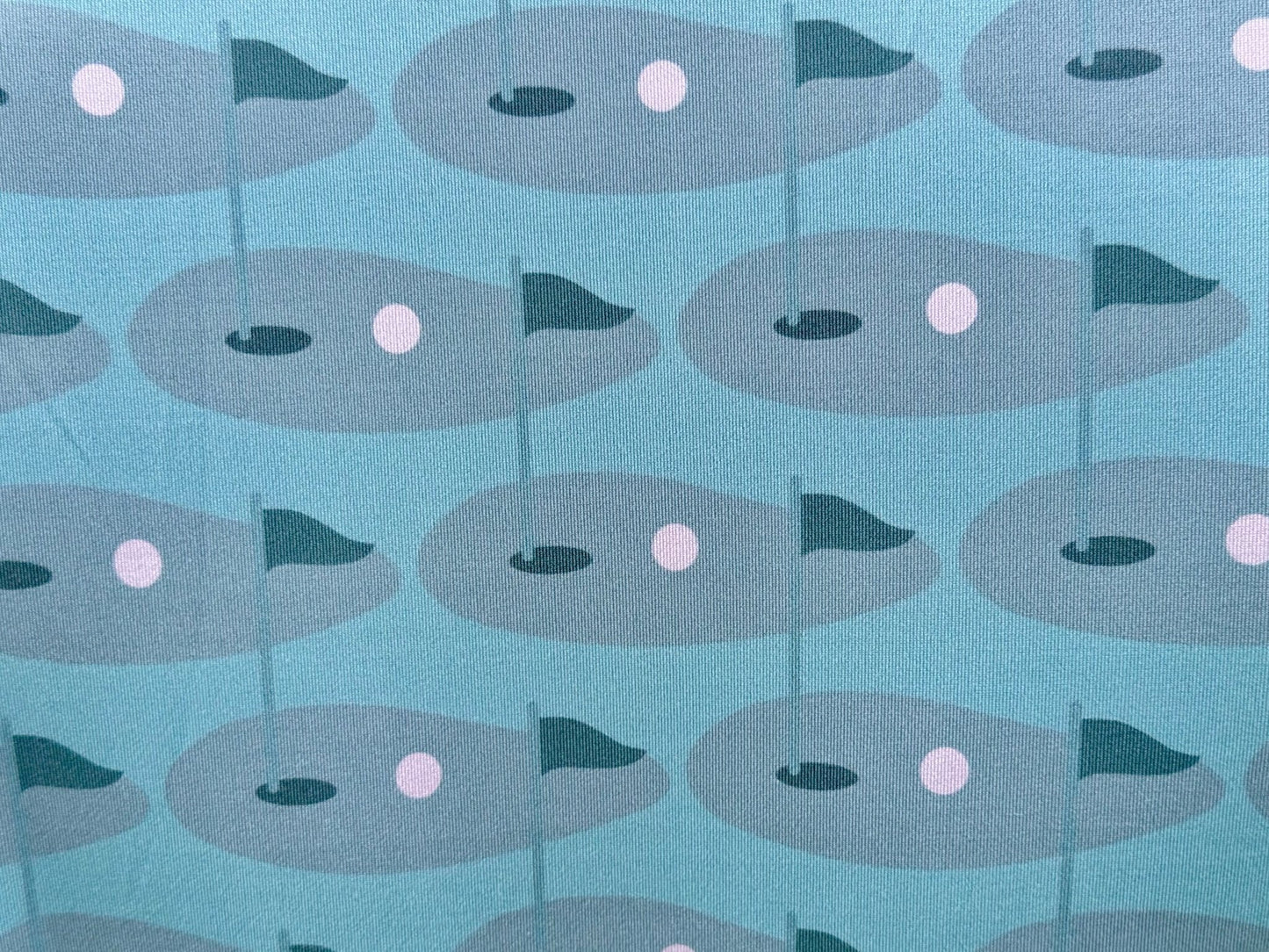 Close up of sublimated print of golf green on Wedge and Wood Greens polo shirt