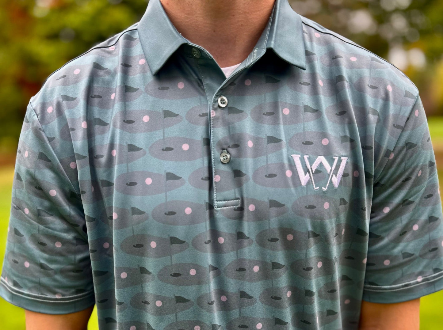 Close up of material and pattern of Wedge and Wood Greens logo polo shirt