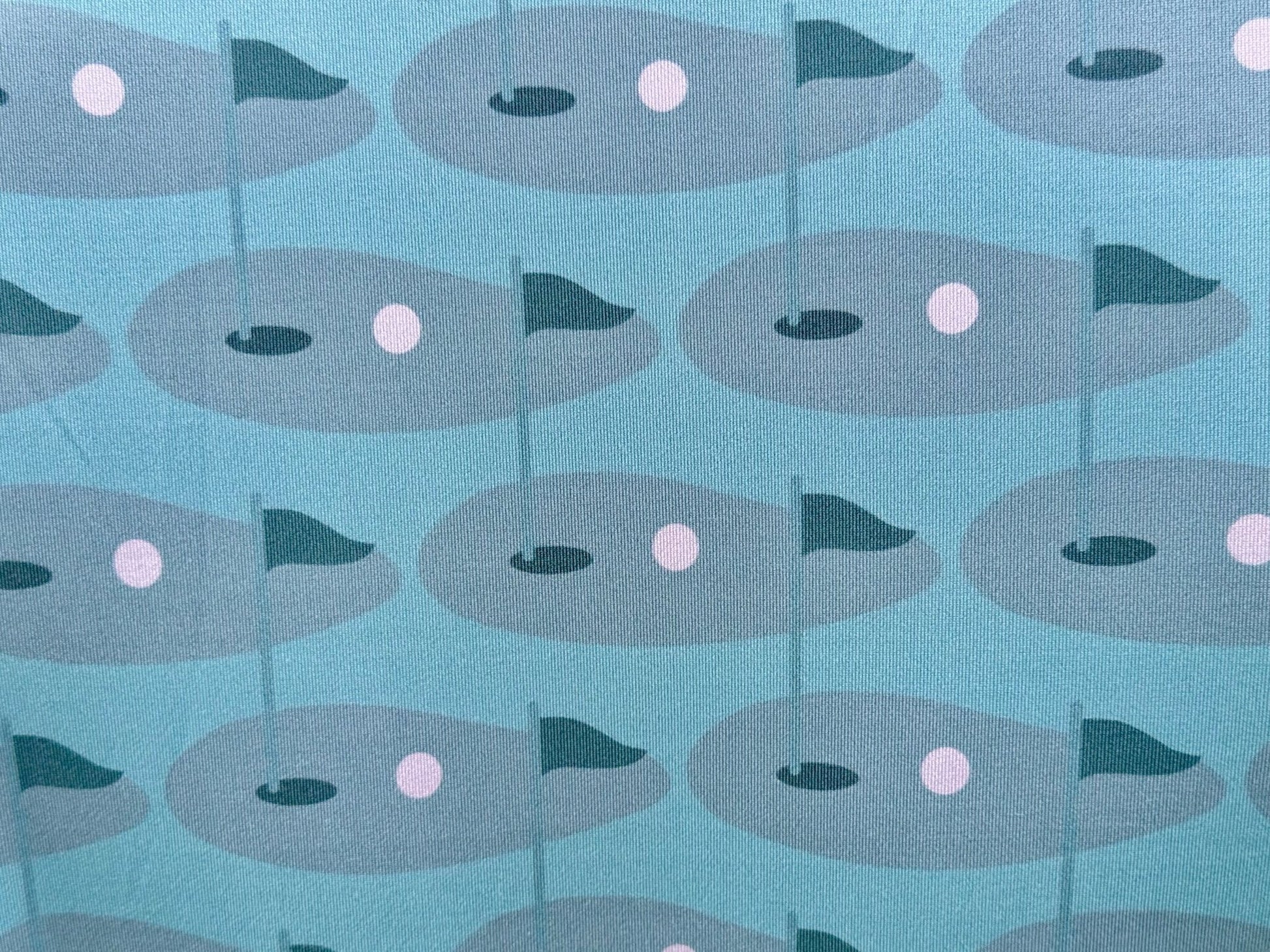 Close up of sublimated print of golf green on Wedge and Wood Greens polo shirt